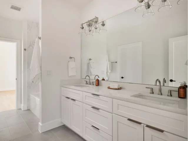 a bathroom with a double vanity sink and mirror