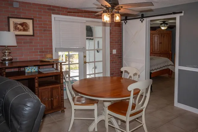 a dining room with furniture and chandelier fan