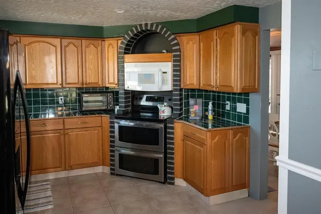 a kitchen with granite countertop a refrigerator and a sink