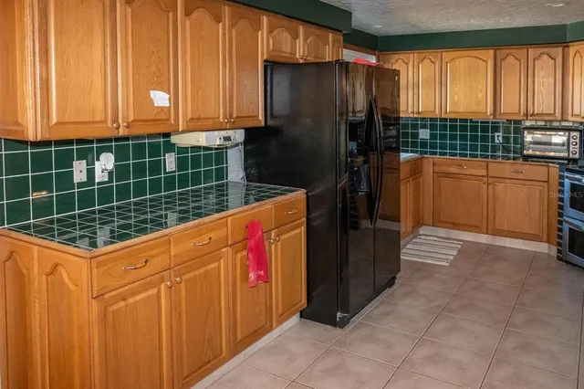a kitchen with stainless steel appliances a stove a refrigerator and wooden cabinets