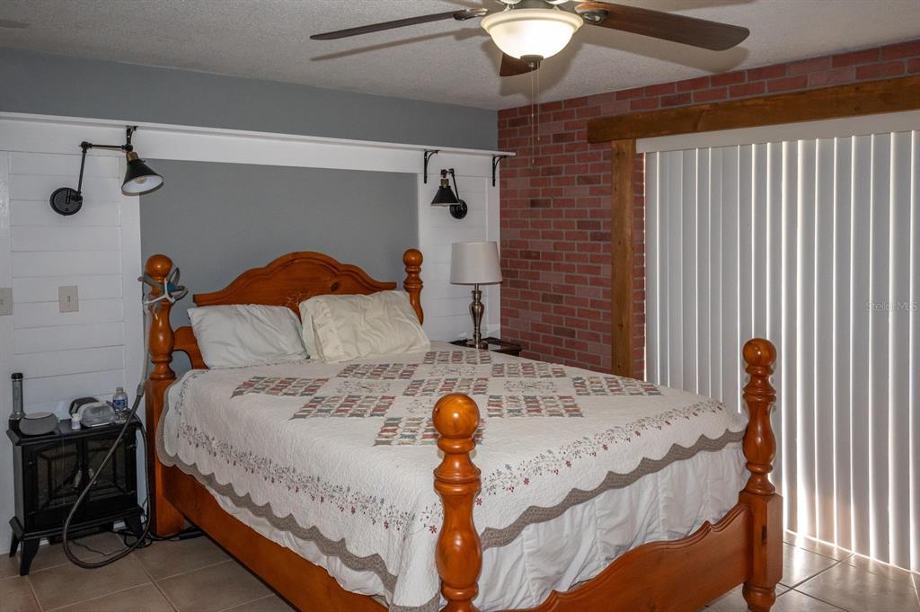 3465 Gulf Lane Rotonda West, FL 33947 - Photo 25 of 42 a bed sitting in a room next to a chair