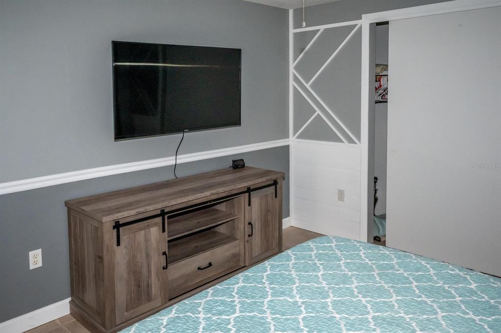 3465 Gulf Lane Rotonda West, FL 33947 - Photo 29 of 42 a room with a dresser and a flat screen tv