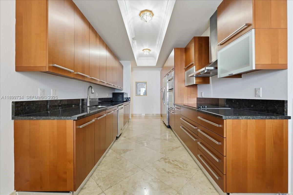 704 North Ocean Boulevard, Unit 1002 Pompano Beach, FL 33062 - Photo 21 of 57 a kitchen with stainless steel appliances granite countertop a stove a sink and a refrigerator