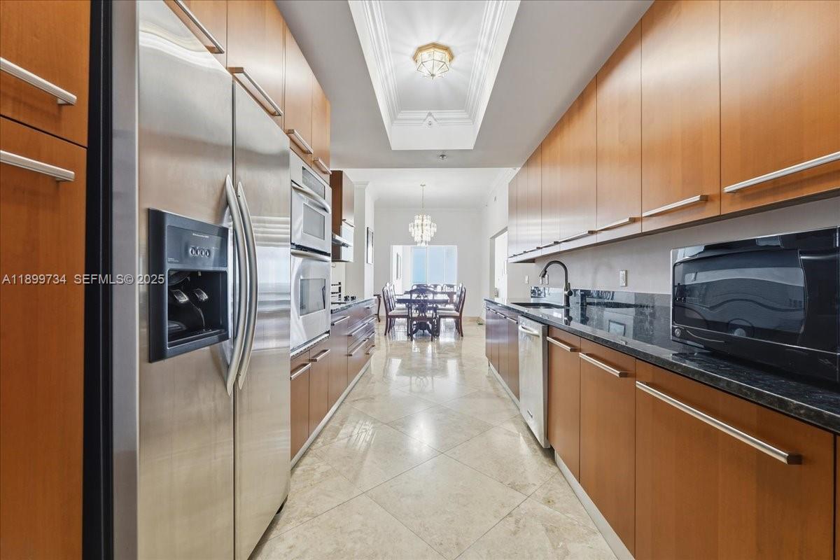 704 North Ocean Boulevard, Unit 1002 Pompano Beach, FL 33062 - Photo 23 of 57 a kitchen with stainless steel appliances granite countertop a refrigerator a oven a stove and a sink with cabinets
