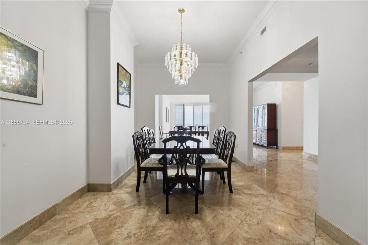 704 North Ocean Boulevard, Unit 1002 Pompano Beach, FL 33062 - Photo 24 of 57 a view of a dining room with furniture and chandelier