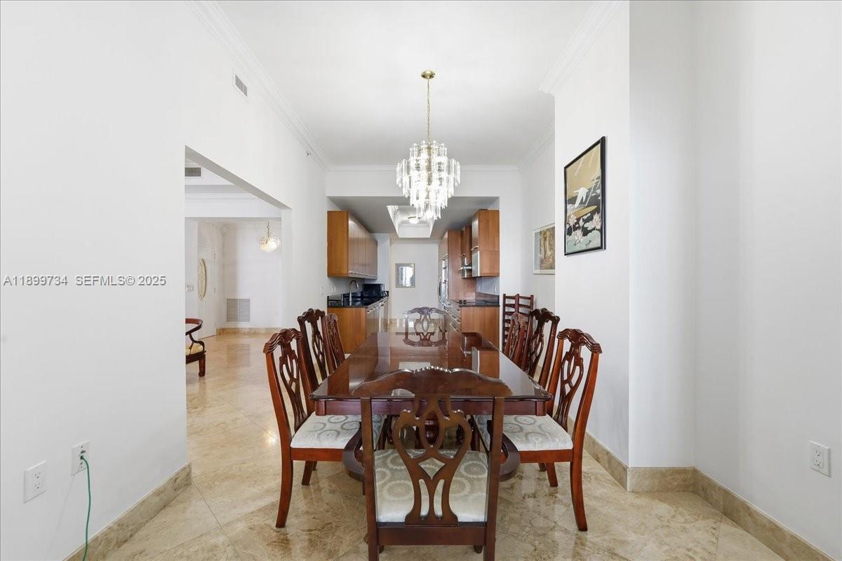 704 North Ocean Boulevard, Unit 1002 Pompano Beach, FL 33062 - Photo 25 of 57 a view of a dining room with furniture and a chandelier