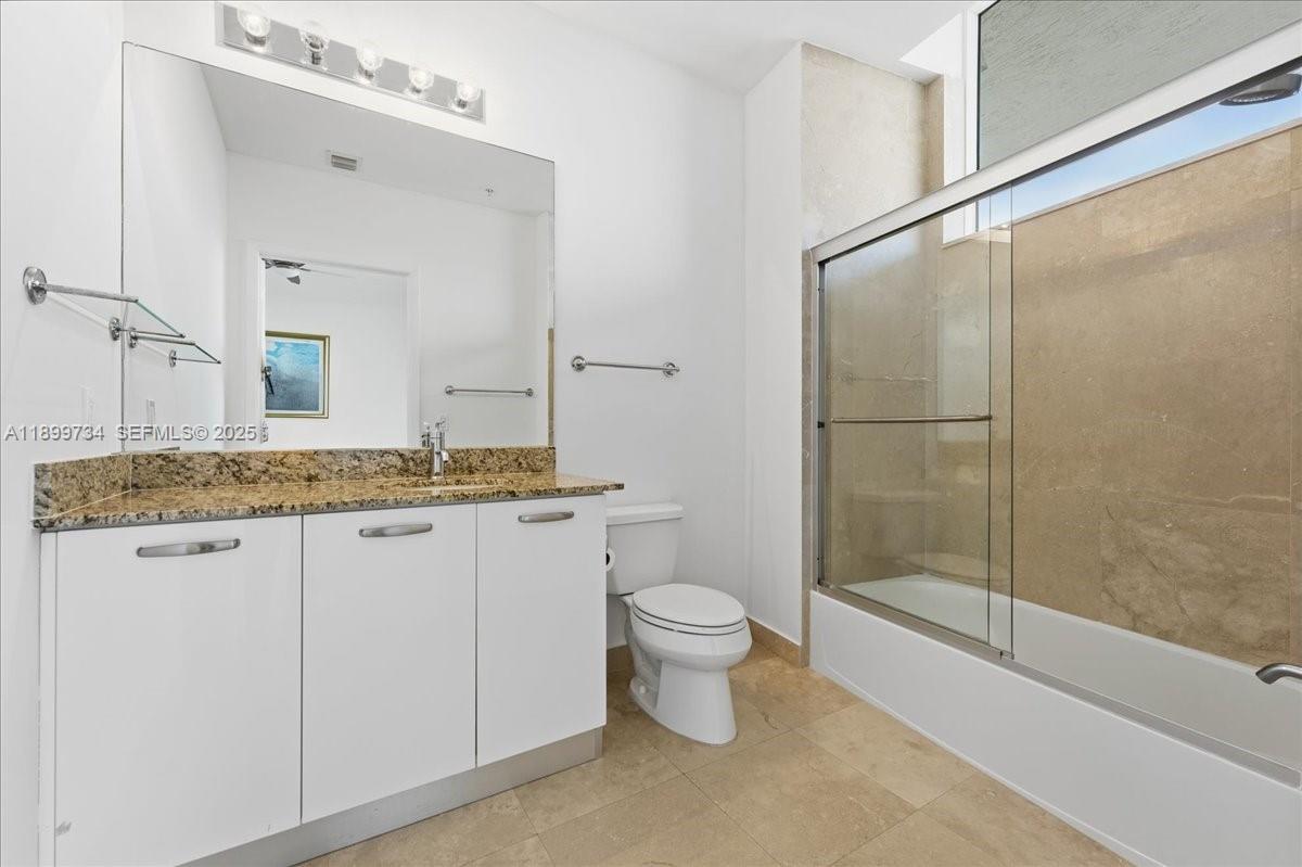 704 North Ocean Boulevard, Unit 1002 Pompano Beach, FL 33062 - Photo 35 of 57 a bathroom with a granite countertop sink a toilet and shower