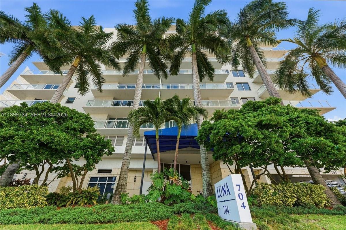 704 North Ocean Boulevard, Unit 1002 Pompano Beach, FL 33062 - Photo 57 of 57 a front view of a house with a yard and palm trees