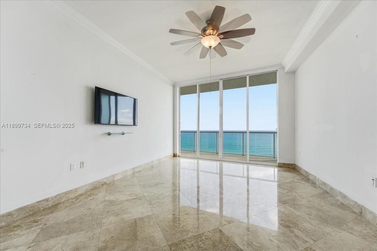 704 North Ocean Boulevard, Unit 1002 Pompano Beach, FL 33062 - Photo 10 of 57 an empty room with windows and ceiling fan