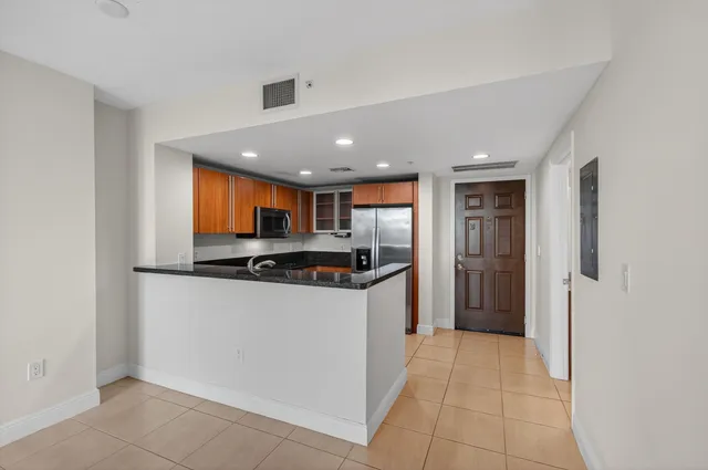 a kitchen with stainless steel appliances granite countertop a refrigerator and a sink