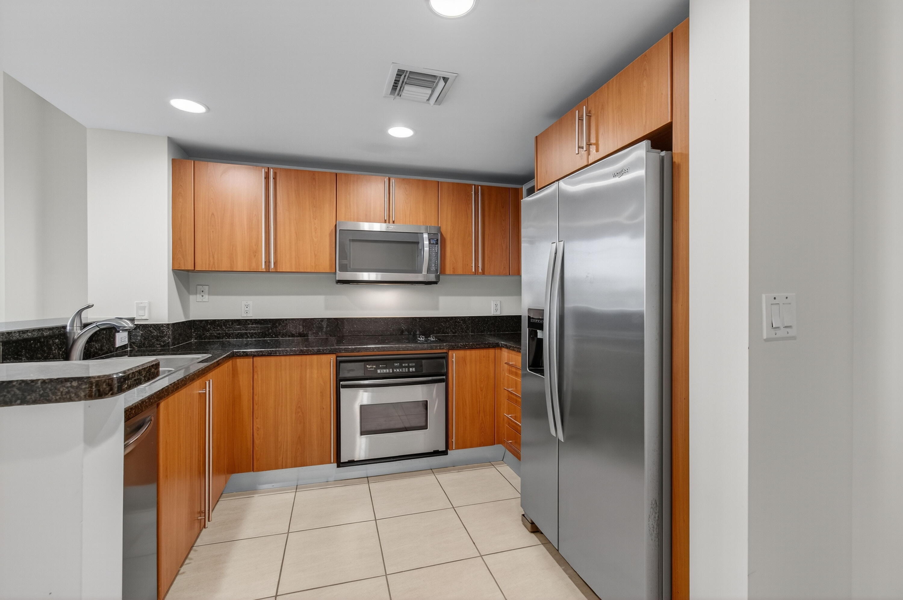 610 Clematis Street, Unit 532 West Palm Beach, FL 33401 - Photo 24 of 63 a kitchen with stainless steel appliances granite countertop a refrigerator and a sink