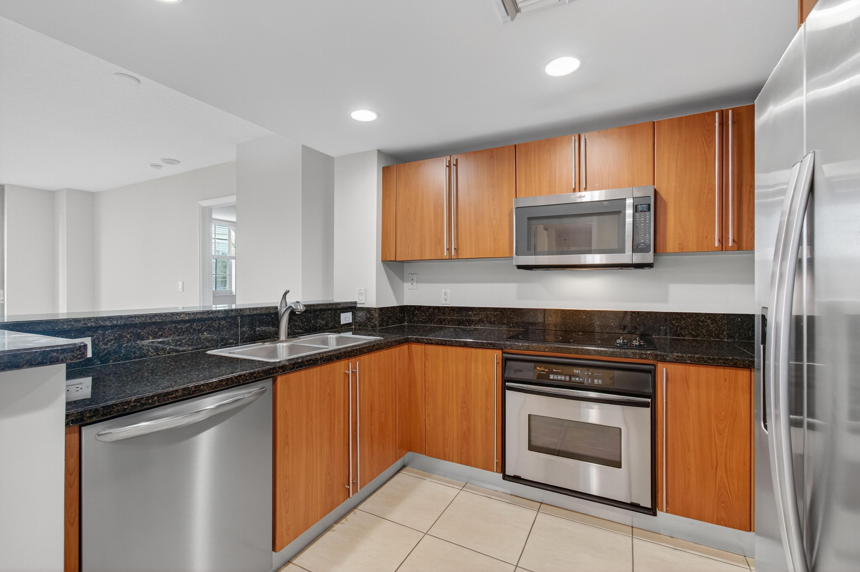 610 Clematis Street, Unit 532 West Palm Beach, FL 33401 - Photo 25 of 63 a kitchen with stainless steel appliances granite countertop a stove a sink and a microwave