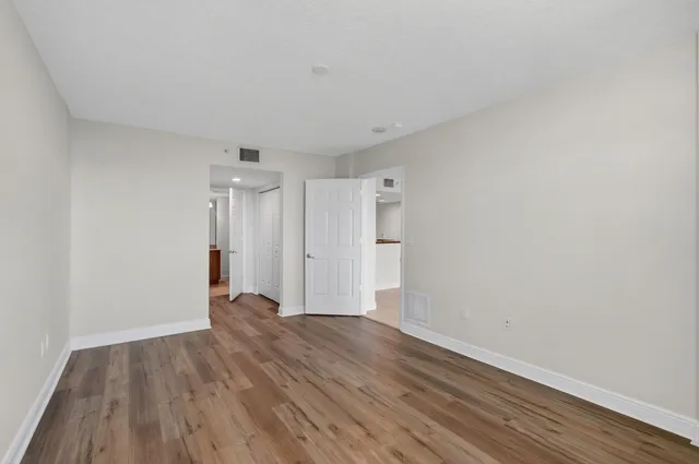 an empty room with wooden floor and windows