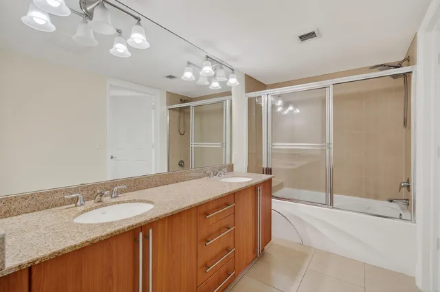a bathroom with a granite countertop toilet sink and mirror