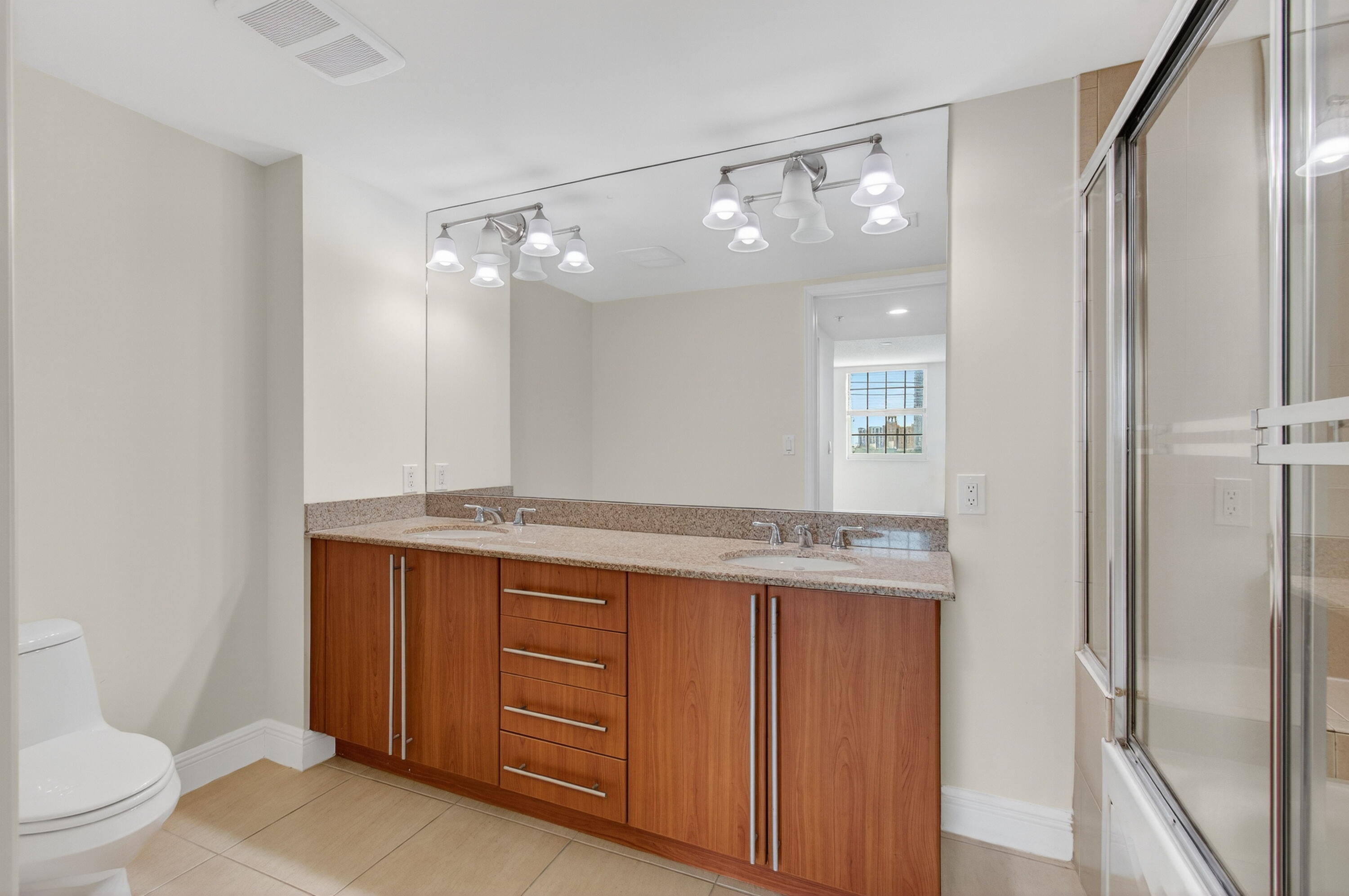 610 Clematis Street, Unit 532 West Palm Beach, FL 33401 - Photo 41 of 63 a bathroom with a granite countertop sink mirror vanity and toilet