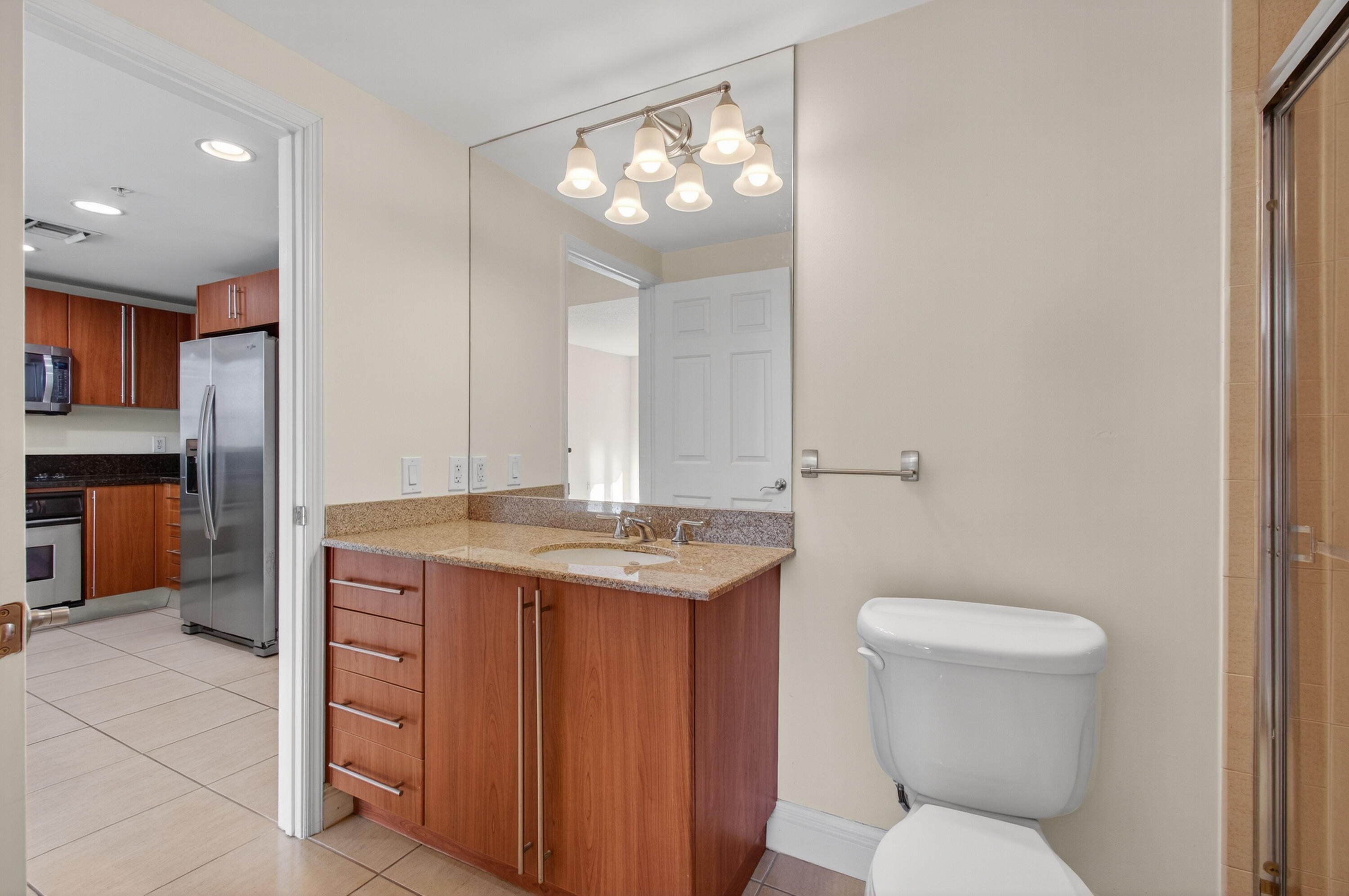 610 Clematis Street, Unit 532 West Palm Beach, FL 33401 - Photo 47 of 63 a bathroom with a granite countertop toilet sink and mirror