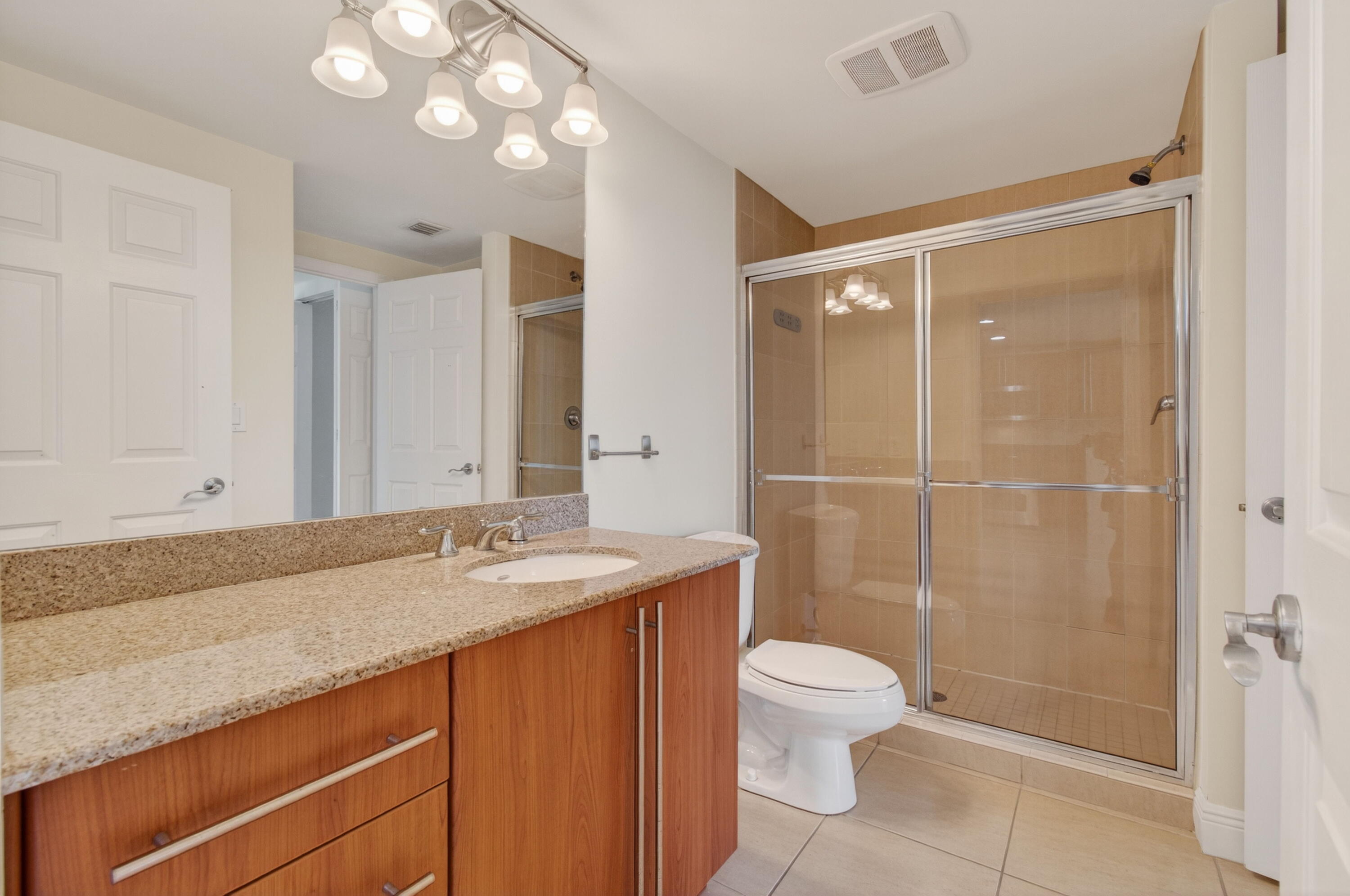 610 Clematis Street, Unit 532 West Palm Beach, FL 33401 - Photo 48 of 63 a bathroom with a granite countertop sink toilet a mirror and shower