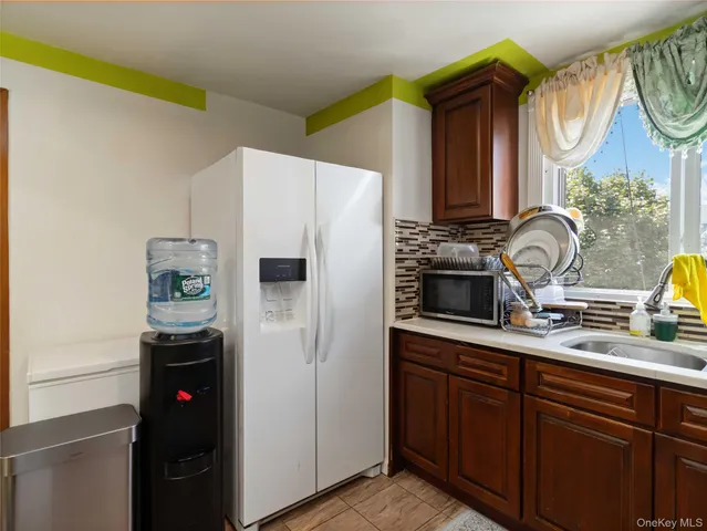 a kitchen with stainless steel appliances a sink cabinets and a window