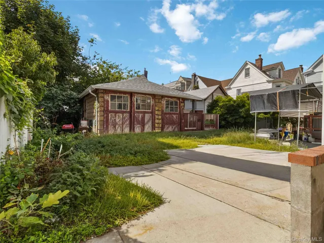 a view of a house with a big yard and large trees