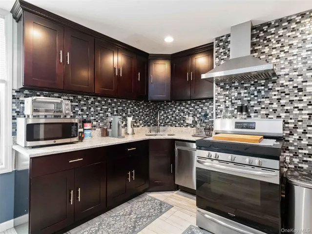 a kitchen with stainless steel appliances a sink stove and cabinets