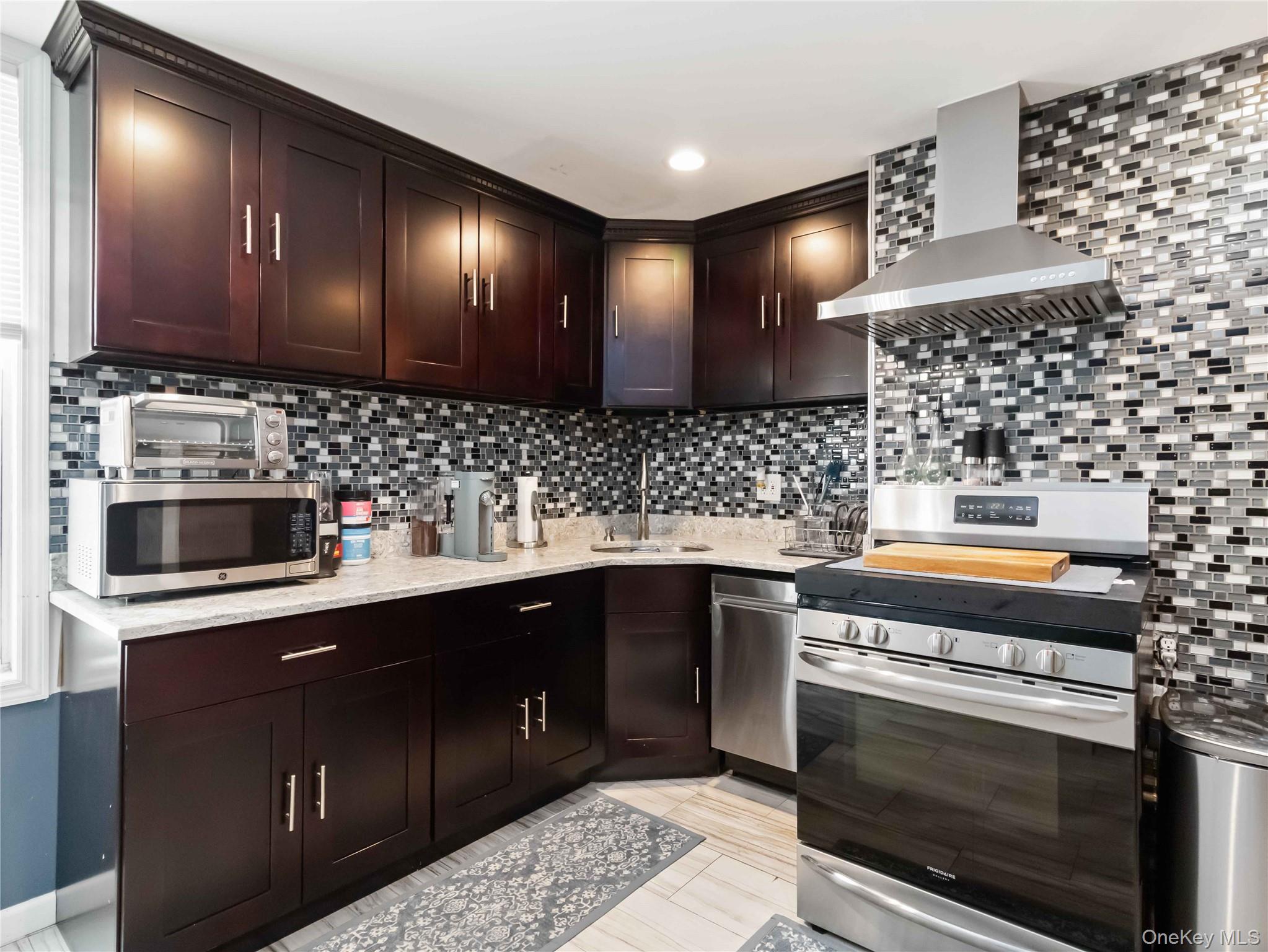 91-16 115th Street Queens, NY 11418 - Photo 4 of 19 a kitchen with stainless steel appliances a sink stove and cabinets