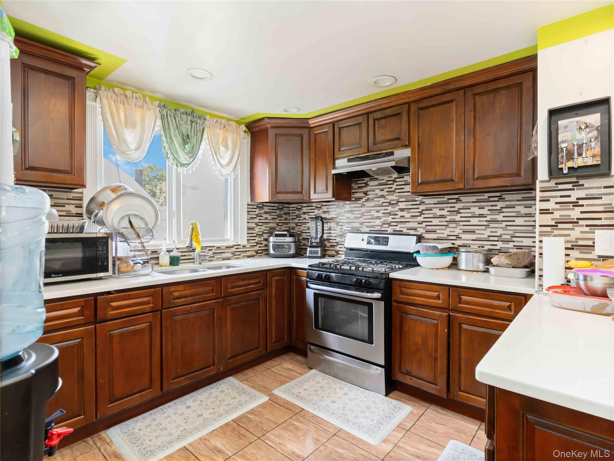 91-16 115th Street Queens, NY 11418 - Photo 10 of 19 a kitchen with stainless steel appliances granite countertop a sink stove and cabinets