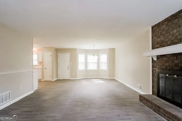 a view of empty room with wooden floor and window
