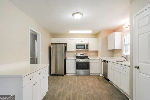 a kitchen with white cabinets stainless steel appliances and sink