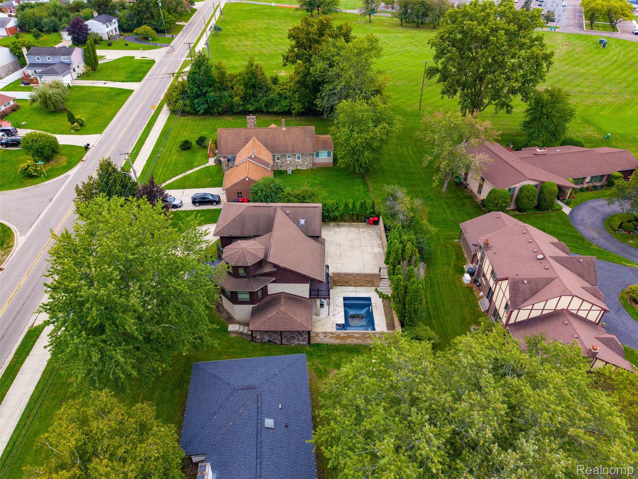 27507 Bell Road Southfield, MI 48034 - Photo 72 of 81 Aerial perspective showcasing multiple properties, featuring a residential building with an outdoor pool, paved patio, and mature landscaping