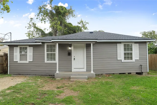 a brick house with a small yard and a large tree