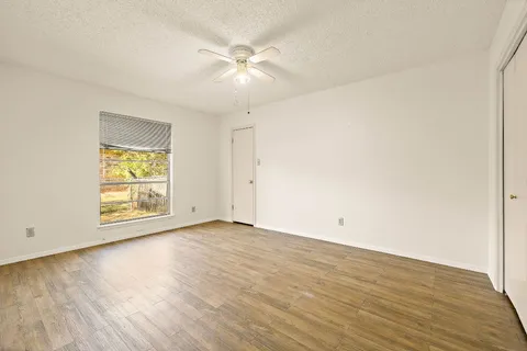 an empty room with wooden floor and windows