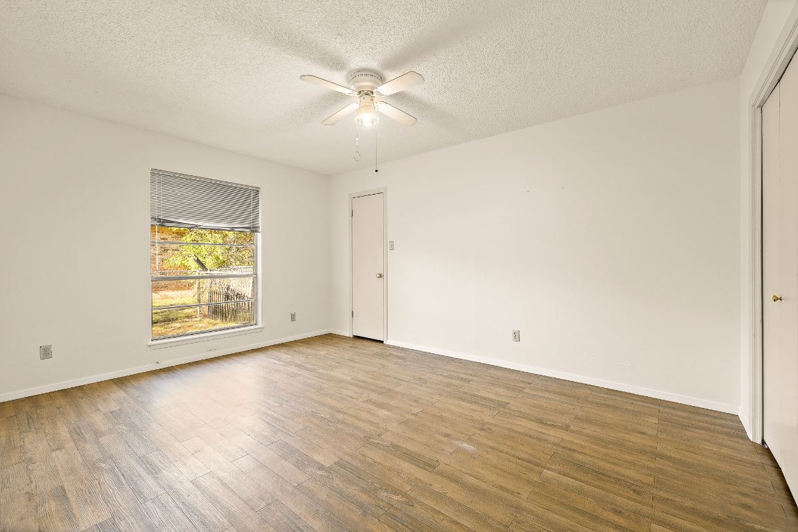 2402 Cottonwood Drive, Unit B Georgetown, TX 78628 - Photo 13 of 20 an empty room with wooden floor and windows