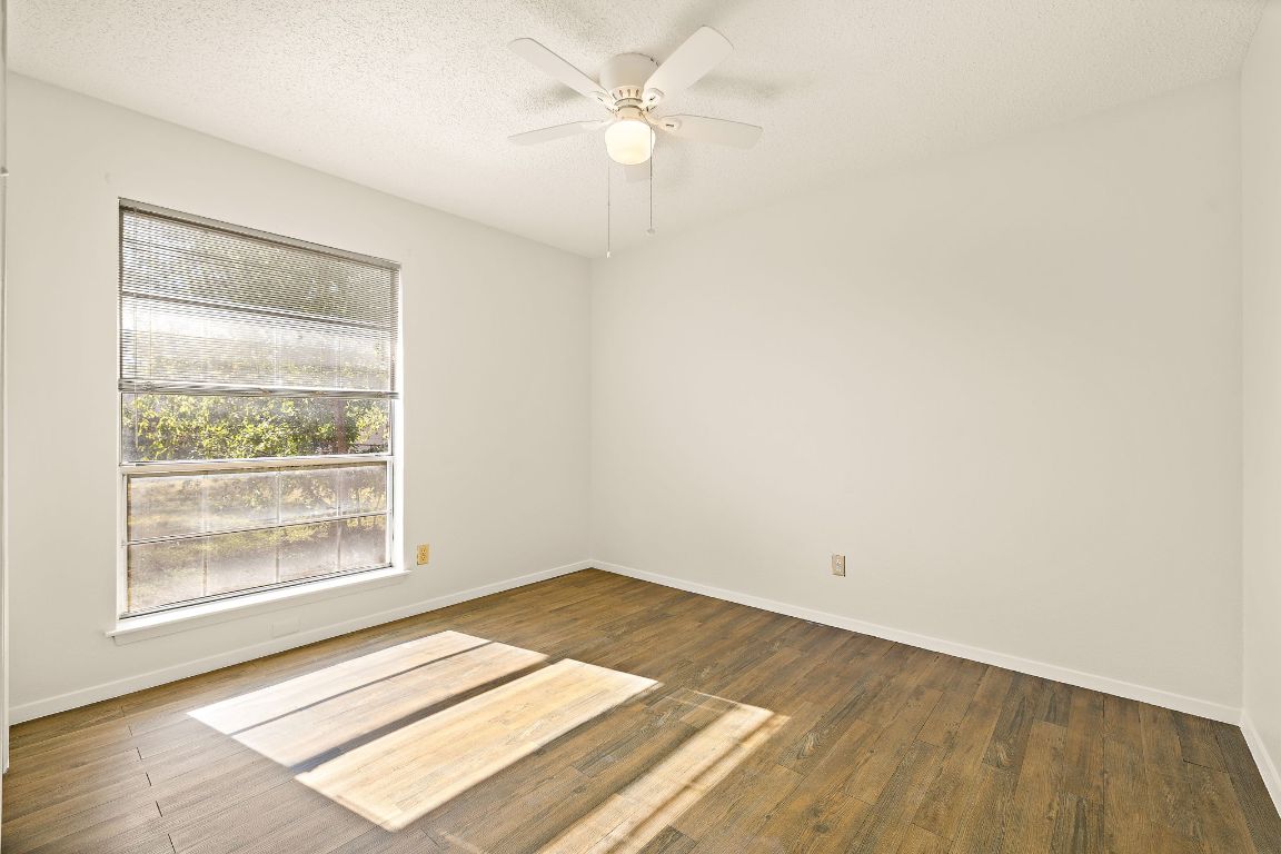 2402 Cottonwood Drive, Unit B Georgetown, TX 78628 - Photo 16 of 20 an empty room with wooden floor and windows