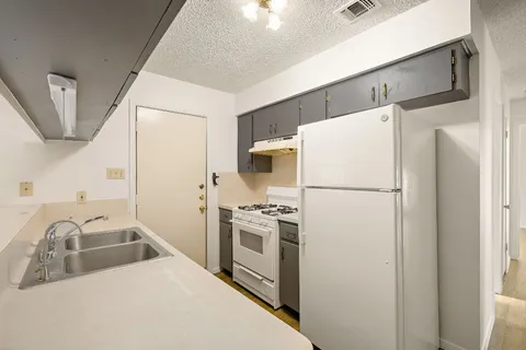 a kitchen with stainless steel appliances a refrigerator sink and stove