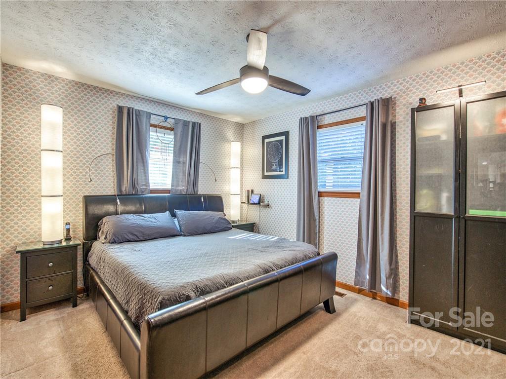 17 Royal Ridge Road Clyde, NC 28721 - Photo 24 of 38 a bedroom with a large bed and a chandelier