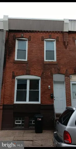 a brick building with a door and a car parked on it