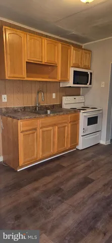 a kitchen with granite countertop wooden cabinets stainless steel appliances and a window