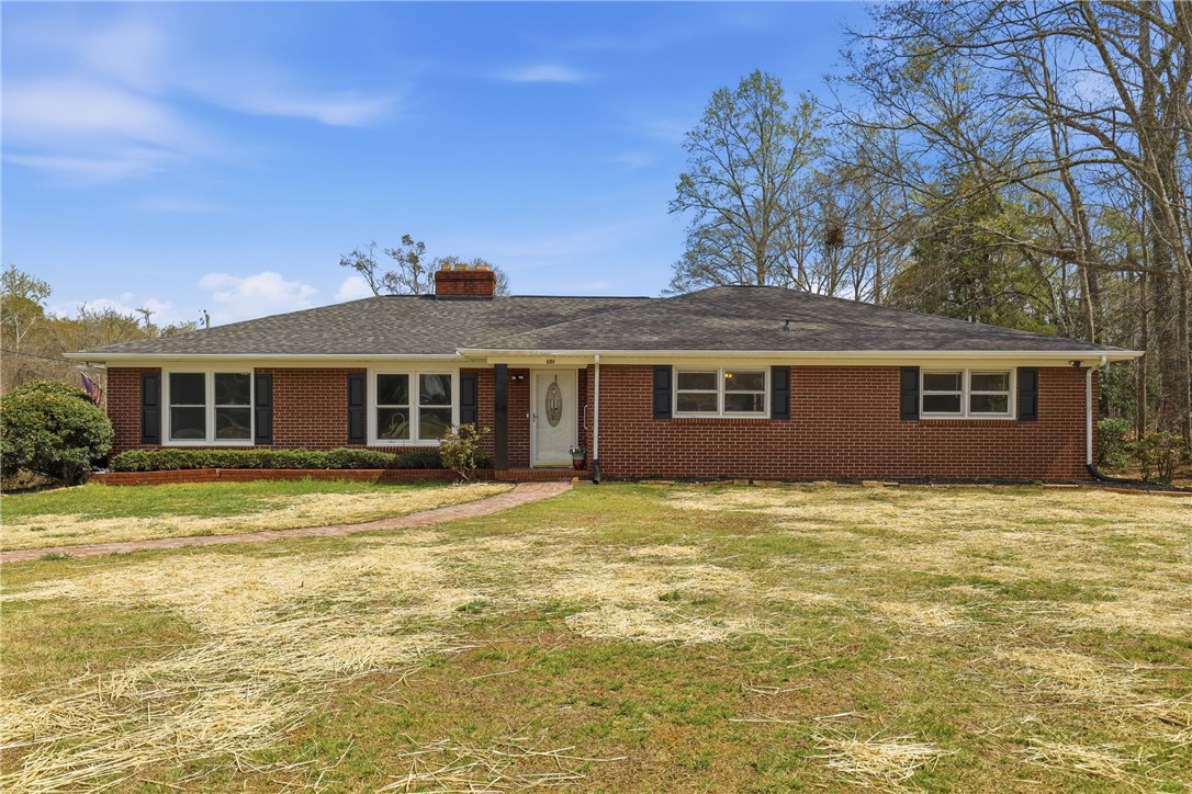 4304 Old Buncombe Road Greenville, SC 29617 - Photo 2 of 49 This charming brick ranch home offers classic appeal and a welcoming facade, set against a backdrop of mature trees.
