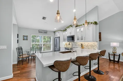 a living room with furniture kitchen view and a large window