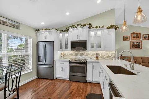 a kitchen with stainless steel appliances a stove sink microwave and refrigerator