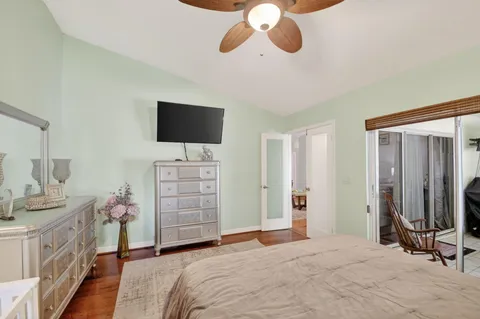 a bedroom with a bed and a flat tv screen on dresser
