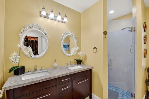 a bathroom with a granite countertop double vanity sinks and a mirror
