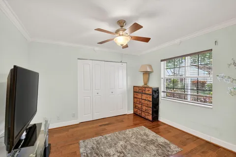 a view of an empty room with window and wooden floor