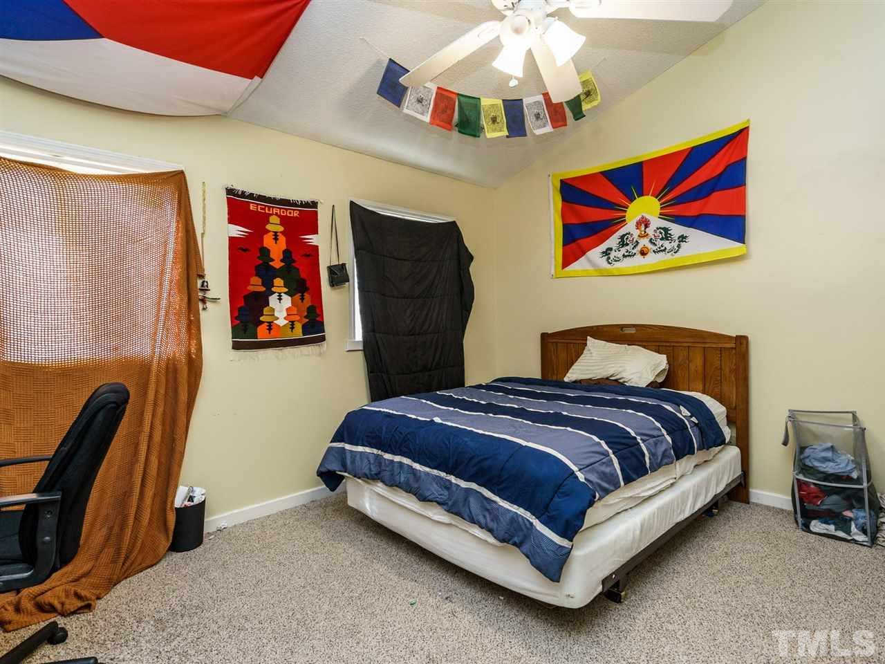 538 Brent Road Raleigh, NC 27606 - Photo 7 of 13 a spacious bedroom with a bed and a chandelier