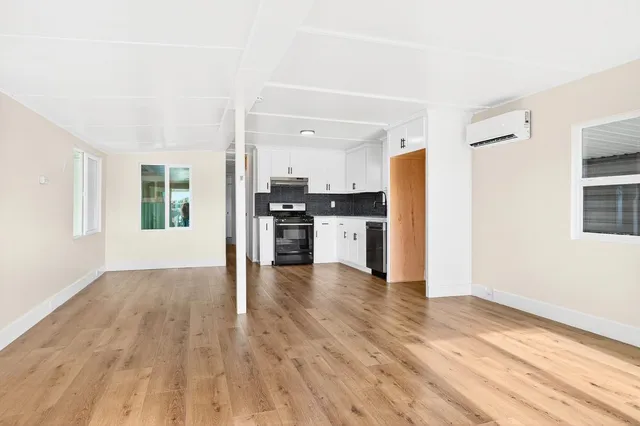 a view of kitchen with wooden floor electronic appliances and window