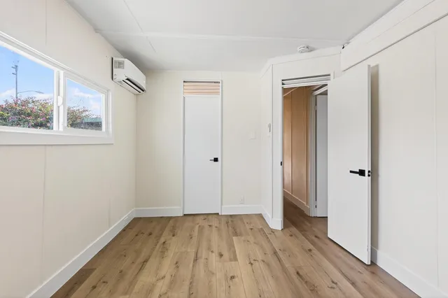 a view of a room with wooden floor and a window