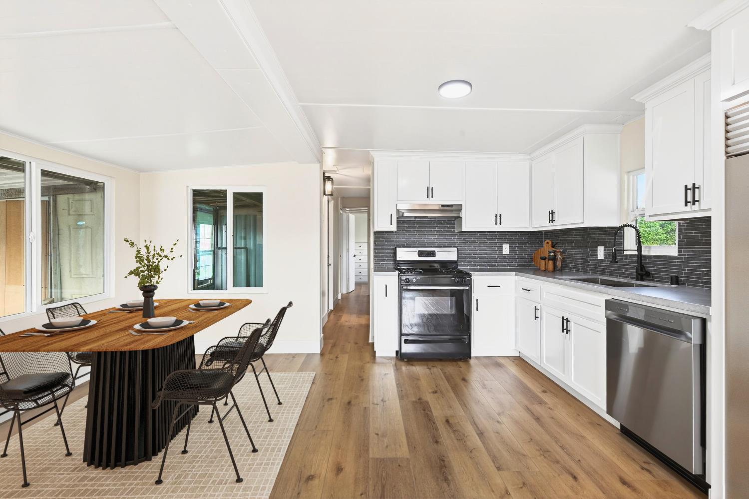 3435 Marfargoa, Unit 48 Stockton, CA 95215 - Photo 4 of 22 a kitchen with stainless steel appliances kitchen island granite countertop a stove top oven a sink a refrigerator with white cabinets and wooden floor