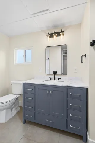 a bathroom with a toilet a sink and mirror
