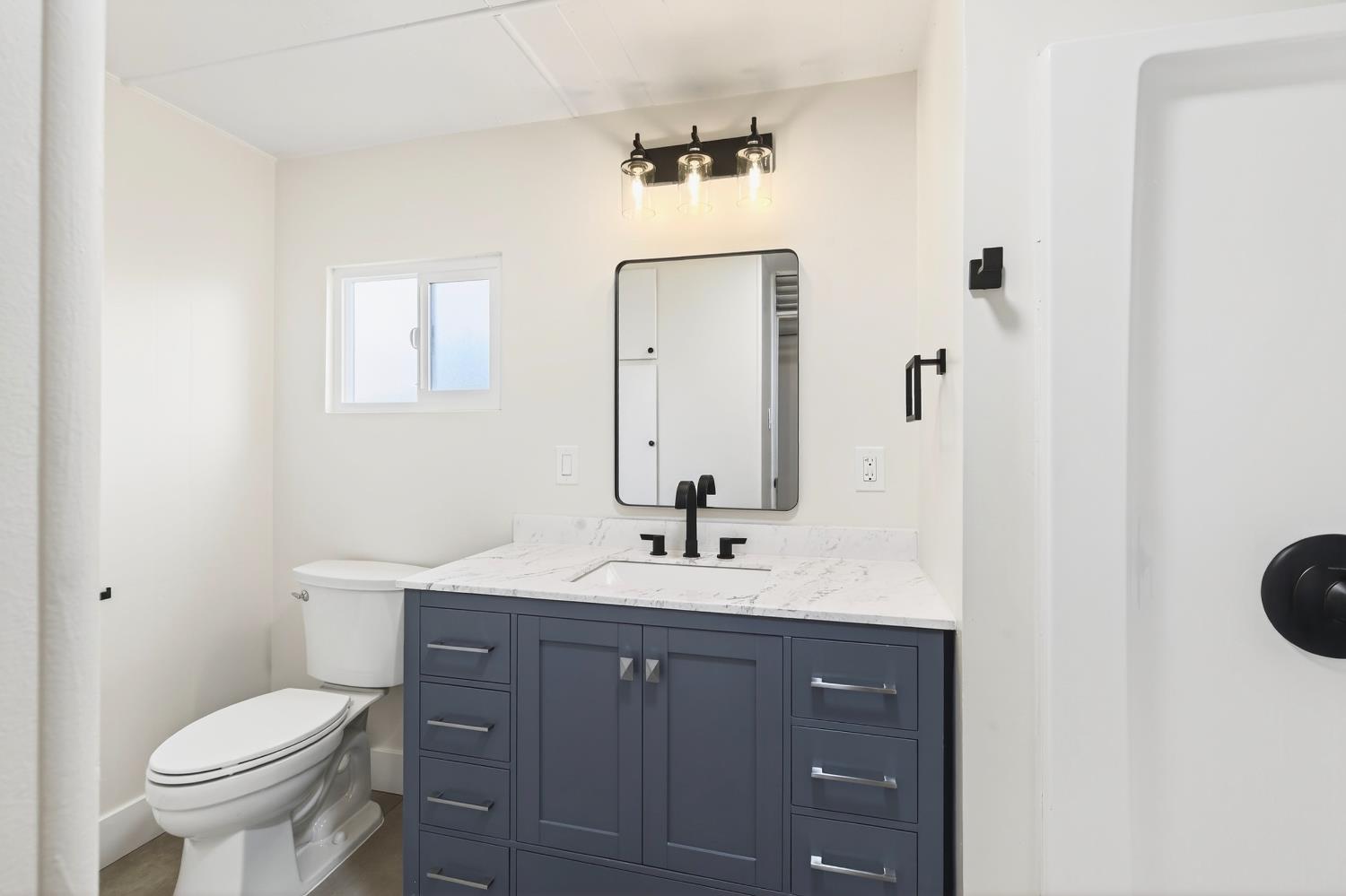 3435 Marfargoa, Unit 48 Stockton, CA 95215 - Photo 9 of 22 a bathroom with a toilet a sink a vanity and mirror