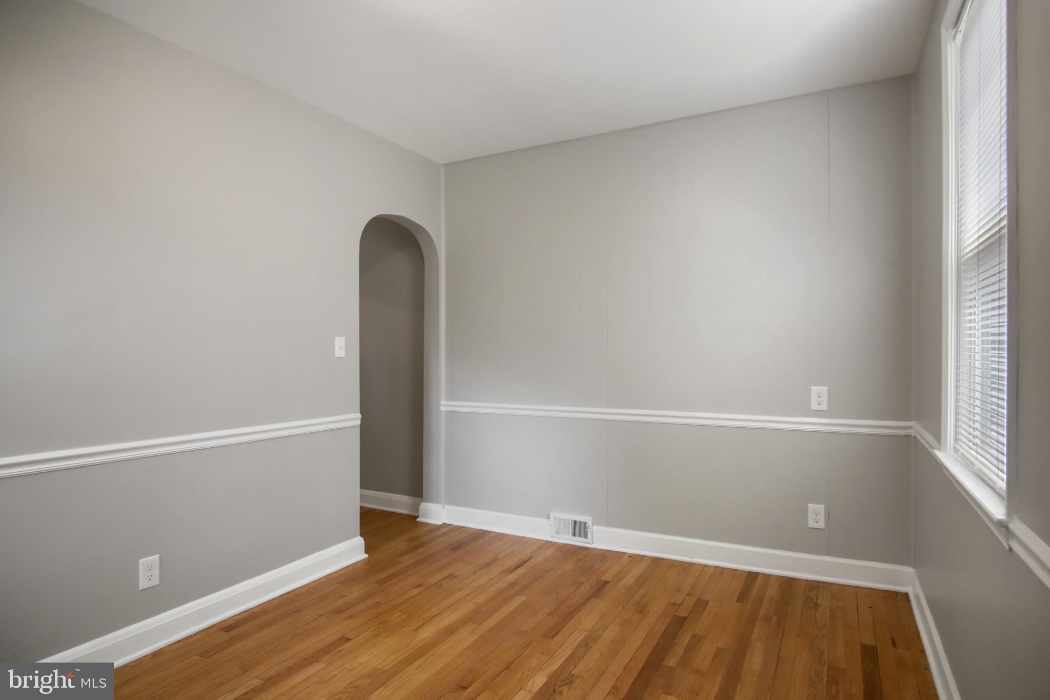 608 Farmhurst Road Baltimore, MD 21208 - Photo 22 of 45 a view of an empty room with wooden floor and a window
